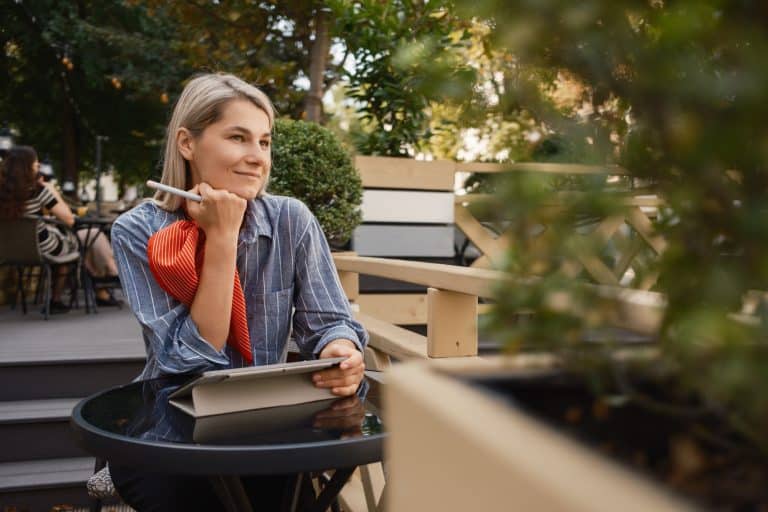 Woman enjoying a peaceful moment at a cafe with a tablet
